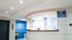 Moderner Empfangsbereich eines Krankenhauses mit Schildern zur Patientenaufnahme und Orientierung.