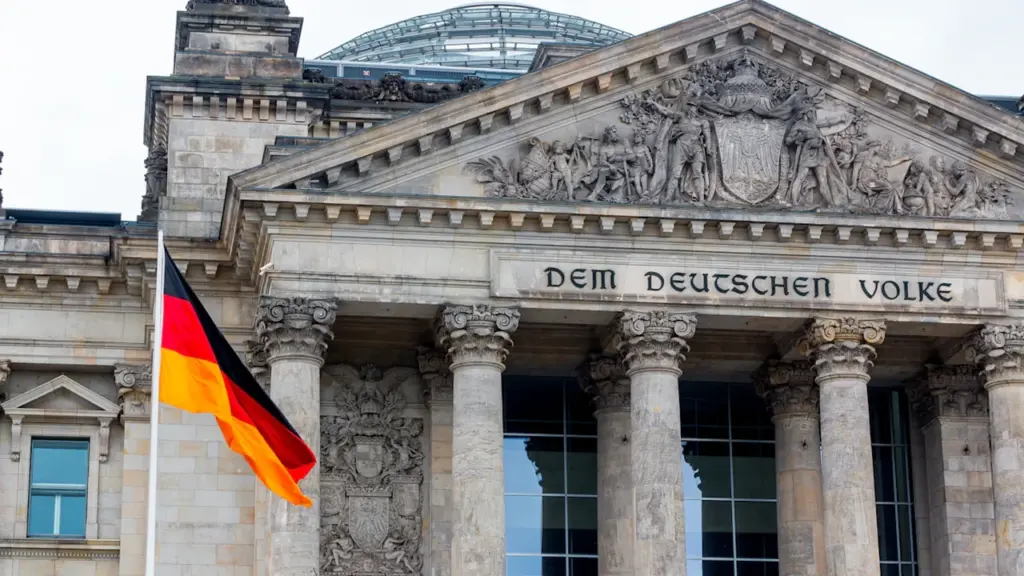 Die deutsche Flagge weht vor der historischen Fassade des Berliner Reichstagsgebäudes.