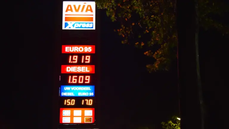 Beleuchtete Preistafel einer Tankstelle in der Nacht mit Kraftstoffpreisen für Benzin und Diesel.