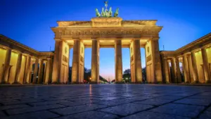 Das Brandenburger Tor in Berlin bei Nacht unter einem tiefblauen Himmel.
