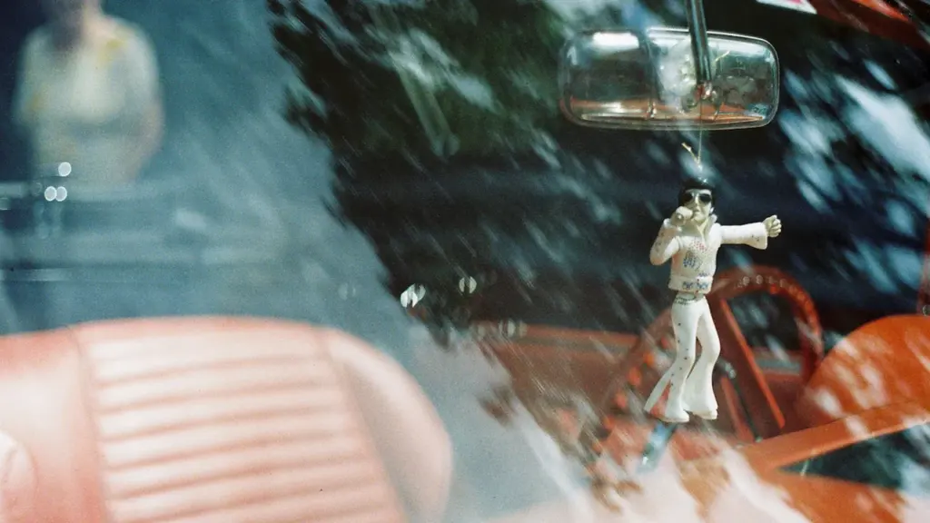 Ein Elvis-Schmuckstück hängt am Rückspiegel eines Autos beim Elvis-Festival in Bad Nauheim.