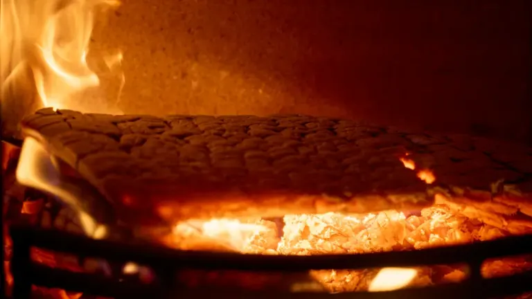 Ein Kaminfeuer mit Brennholz symbolisiert die Heizkosten im Kontext der CO2-Bepreisung.