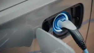 Ein Ladekabel ist in die Ladebuchse eines modernen Elektroautos eingesteckt.