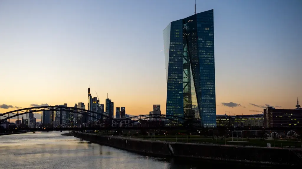 Blick von der Osthafenbrücke auf die Europäische Zentralbank und Frankfurter Skyline bei Sonnenuntergang.