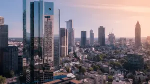 Blick auf die Frankfurter Skyline mit dem markanten Deutsche Bank Turm bei Tageslicht.