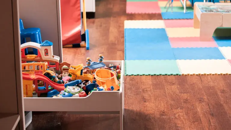 Bunte Spielsachen und Spielmatten in einem hellen, freundlichen Kita-Gruppenraum in Freiburg.