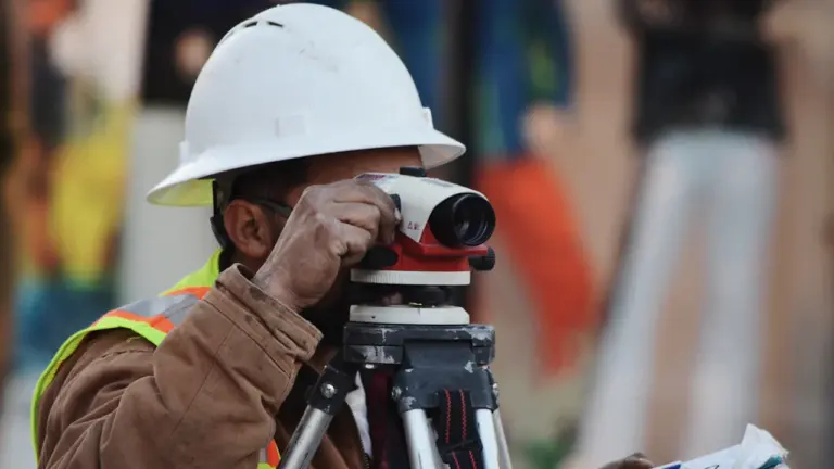 Ein Bauarbeiter bei der Arbeit bei sommerlicher Hitze auf einer Baustelle.