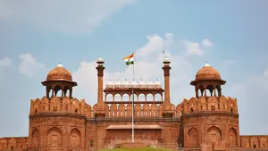 Das historische Rote Fort in Delhi mit einer wehenden indischen Flagge bei Tageslicht.
