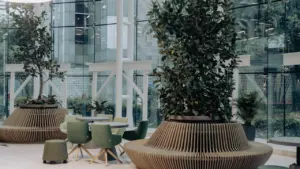 Helle, moderne Bürolobby mit großen Glasfronten, Pflanzen und organischen Sitzmöbeln für ein ruhiges Arbeitsumfeld.