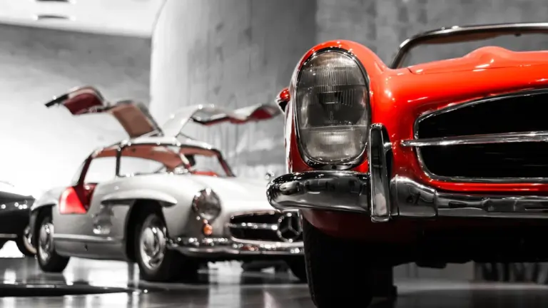 Zwei klassische Mercedes-Benz Fahrzeuge in der modernen Ausstellung des Stuttgarter Museums.