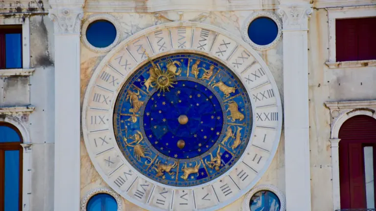 Historische astronomische Uhr mit Sternzeichen an einer prachtvollen Fassade eines alten Gebäudes.
