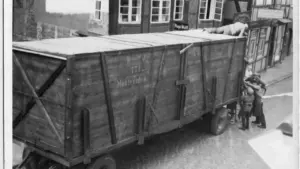 Ein großer, alter Holzwagen mit der Aufschrift Montevideo steht in einer gepflasterten deutschen Altstadtstraße.