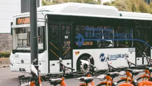 Ein moderner Stadtbus parkt auf einem belebten Platz in der Stadt.